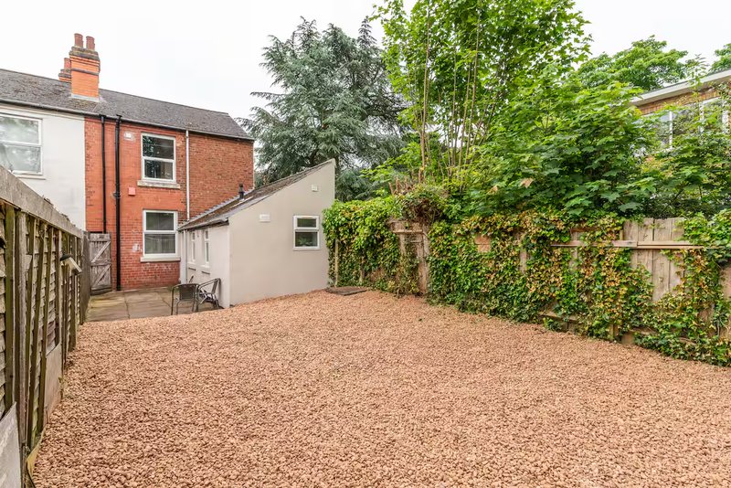 Brick semi-detached house with patio area and gravel garden
