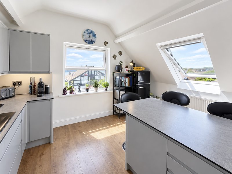 Fully equipped modern kitchen and dining area with oven, hob, microwave, dishwasher, kettle, toaster and coffee machine.