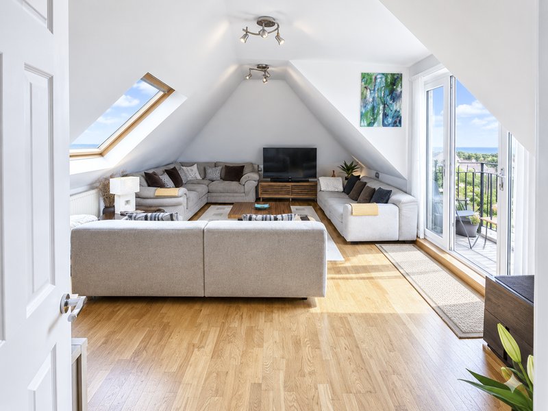 Bright loft living room, balcony doors with sea views.