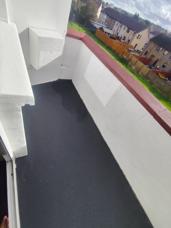 Exterior stairwell with dark steps, white walls, and view of surrounding residential buildings