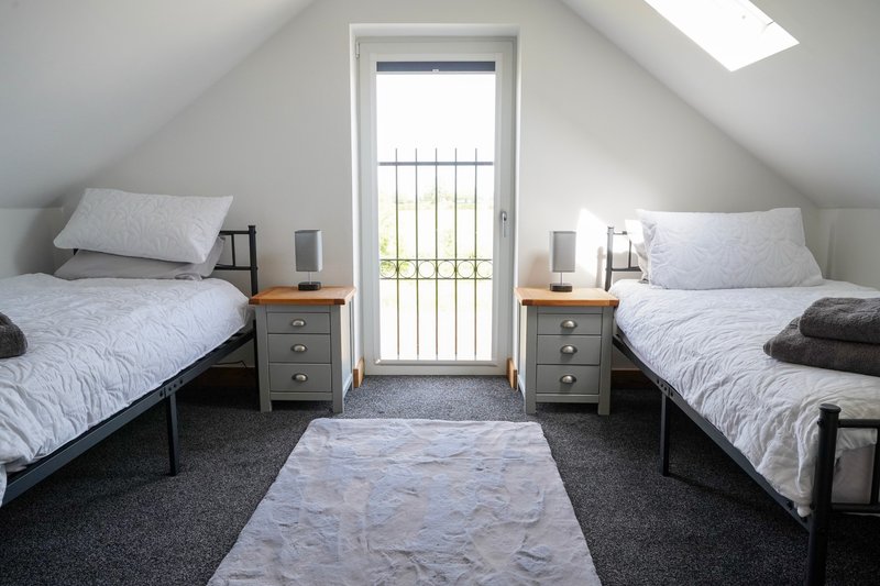 This bright and comfortable twin bedroom features two full-size single beds, making it an ideal arrangement for contractors or colleagues travelling together.