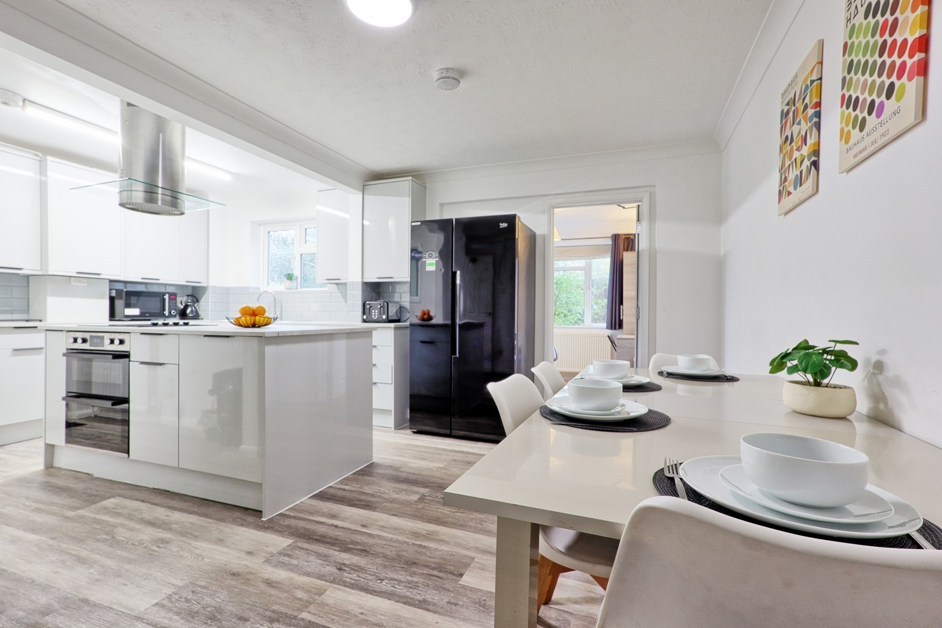 Modern open-plan kitchen and dining area with white cabinetry, island, and dining table set for two
