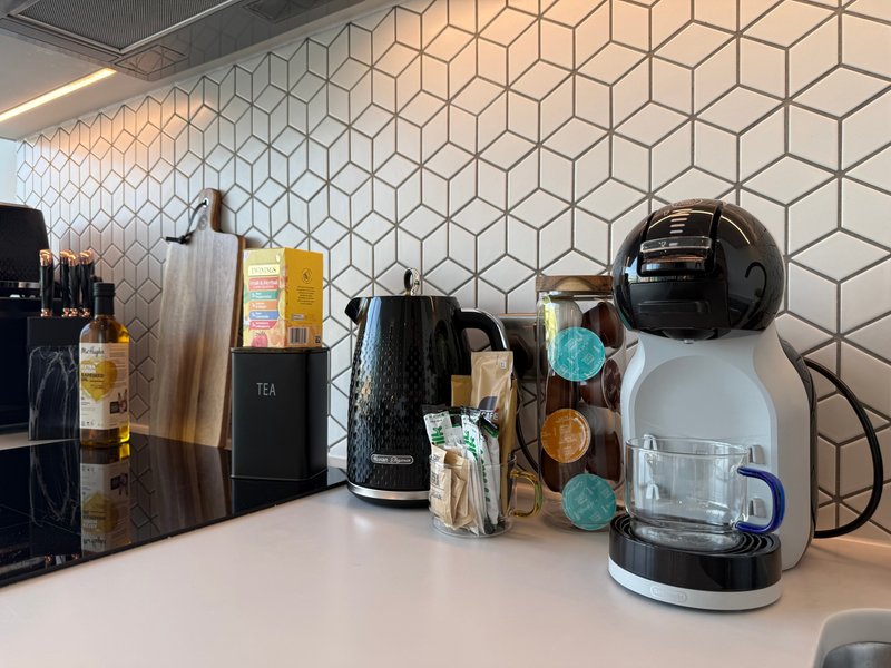 Kitchen counter with coffee maker, tea dispenser, and various branded kitchen appliances and containers