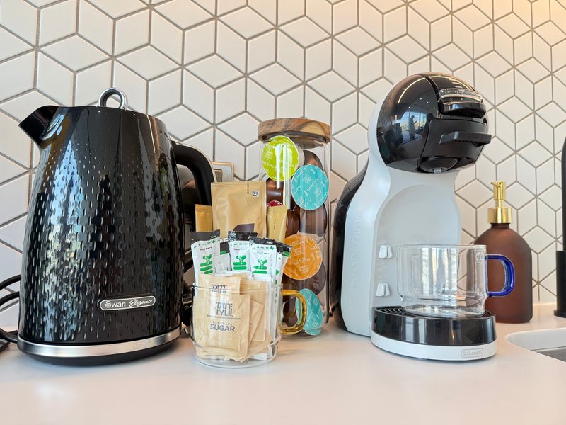 Kitchen counter with electric kettle, coffee maker, and various branded groceries and items