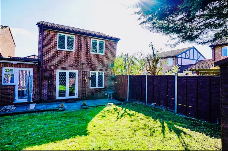 Brick house with garden, patio area, fenced yard and green lawn