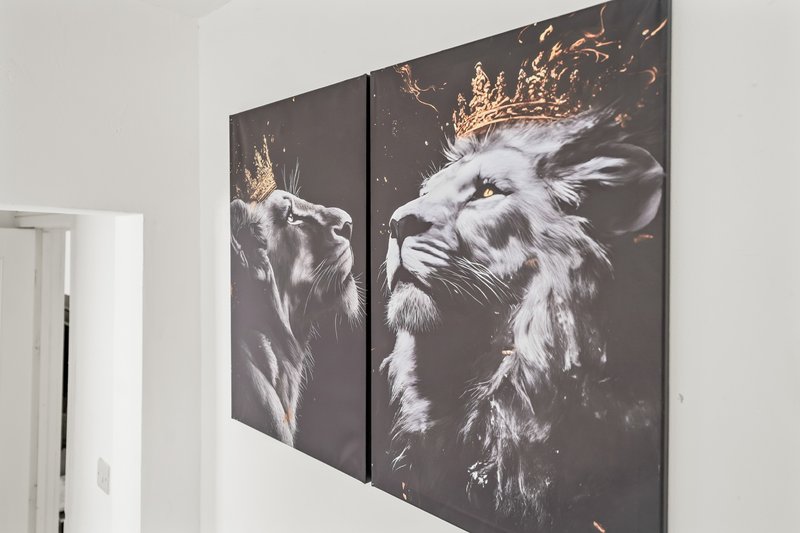 White interior wall with two-panel decorative artwork featuring stylized animal portraits with gold accents