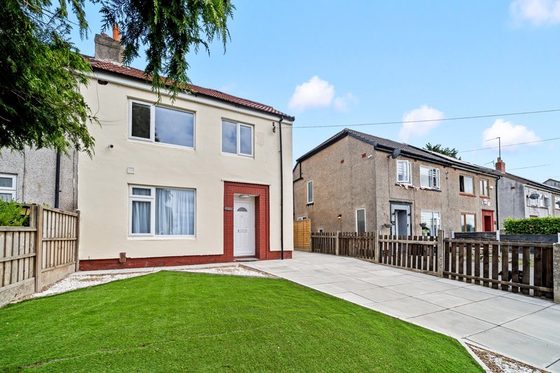 Semi-detached house with red door, front garden and paved patio area