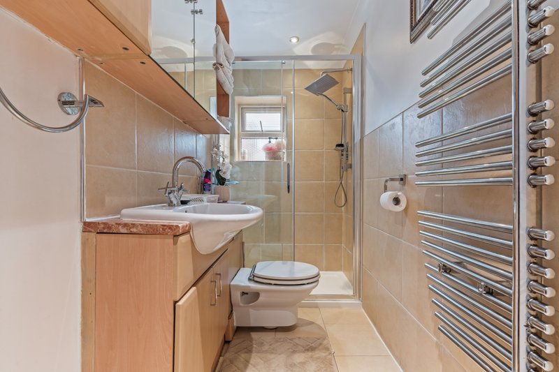 Modern bathroom with walk-in shower, vanity sink, heated towel rail and toilet