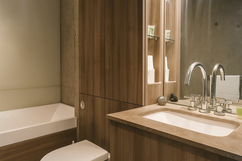 Modern bathroom with wooden vanity, undermount sink, chrome faucet and bathtub