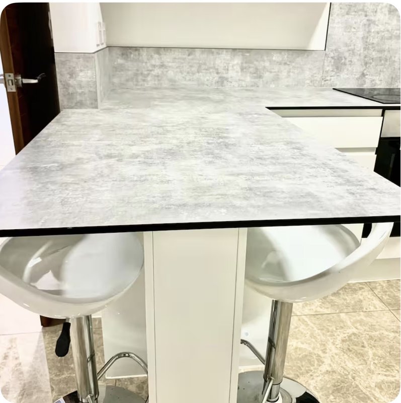 Kitchen with marble countertop, white cabinetry, and modern bar stools