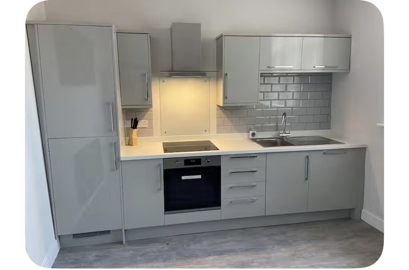 Modern grey kitchen with built-in oven, cooktop, sink and integrated fridge