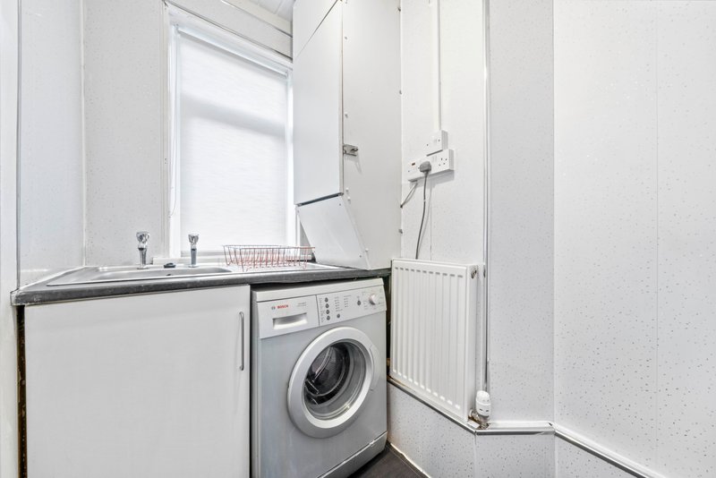Compact utility room with washing machine, sink and window