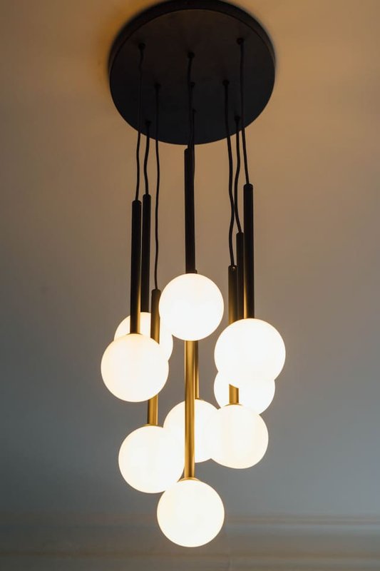 Modern pendant light fixture with multiple white globe bulbs and black cord suspension