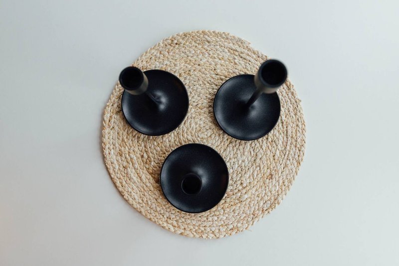 Decorative wall art made from woven placemat and black ceramic bowls arranged as face