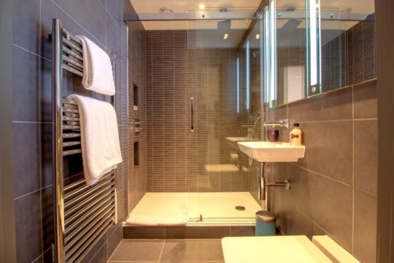 Modern bathroom with walk-in shower, heated towel rail, vanity sink and mirror