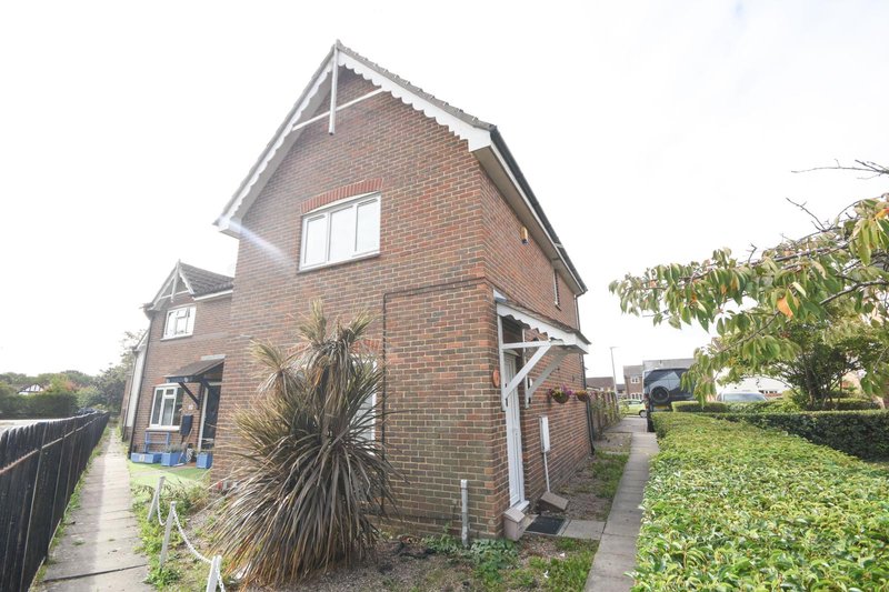 Brick detached house with pitched roof, front garden and driveway access