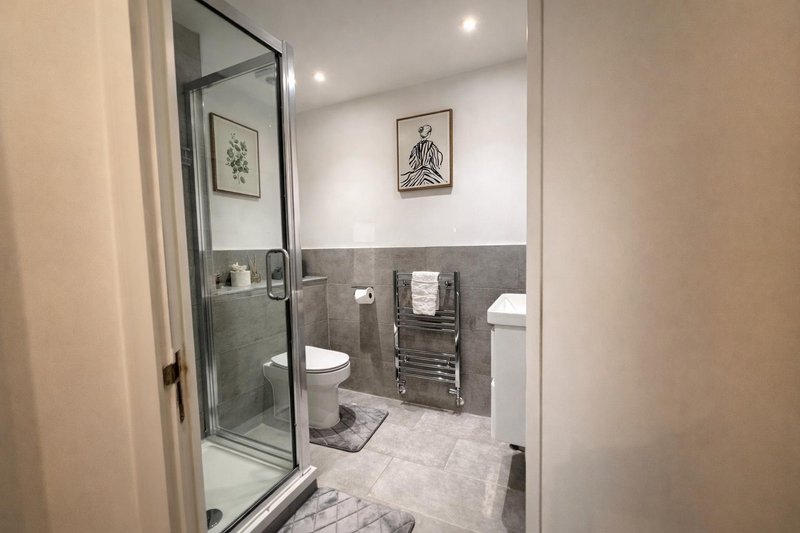 Ensuite Modern bathroom with walk-in shower, toilet, heated towel rail and marble flooring.