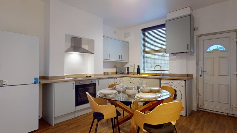 Modern kitchen-diner with white cabinetry, wooden countertops, dining table and yellow chairs