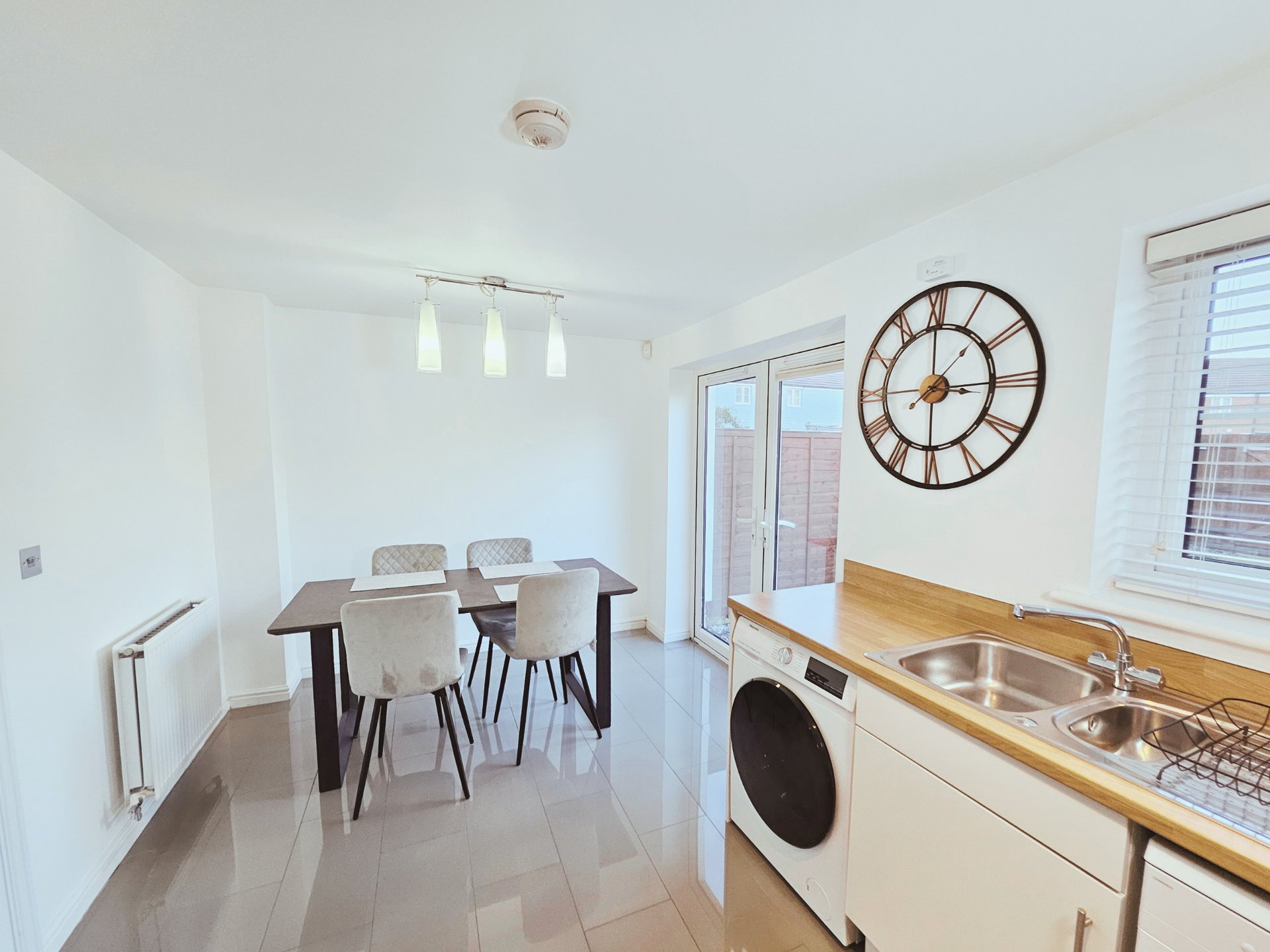 Open-plan kitchen and dining area with cream cabinetry, wooden countertops, dining table and chairs