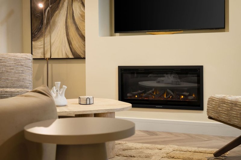 Modern living room with fireplace, TV, round table, and contemporary artwork on walls