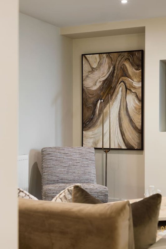 Modern living room corner with upholstered chairs and abstract wall art