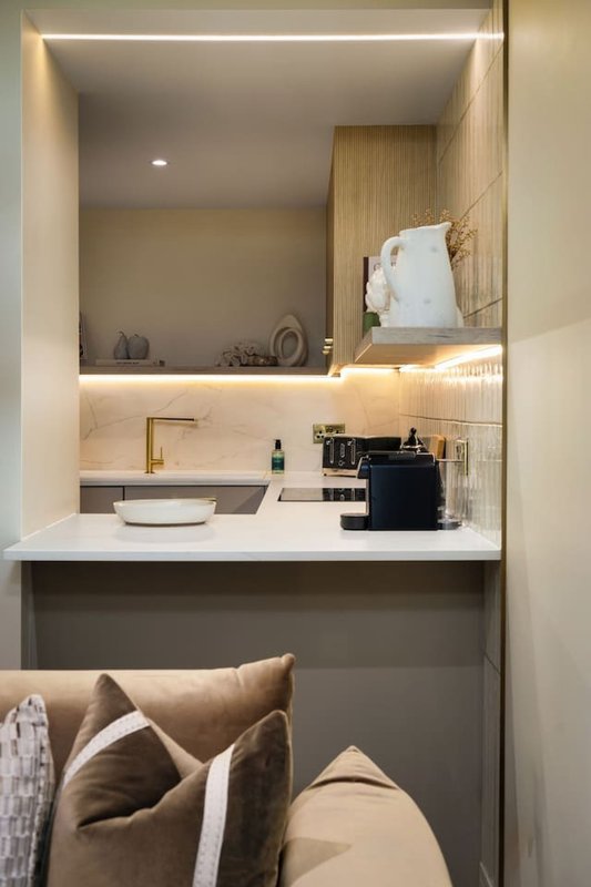 Modern bathroom with vanity sink, mirror, wood paneling, and decorative cushions below