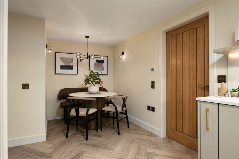 Modern dining area with round table, black chairs, pendant light and wooden doors