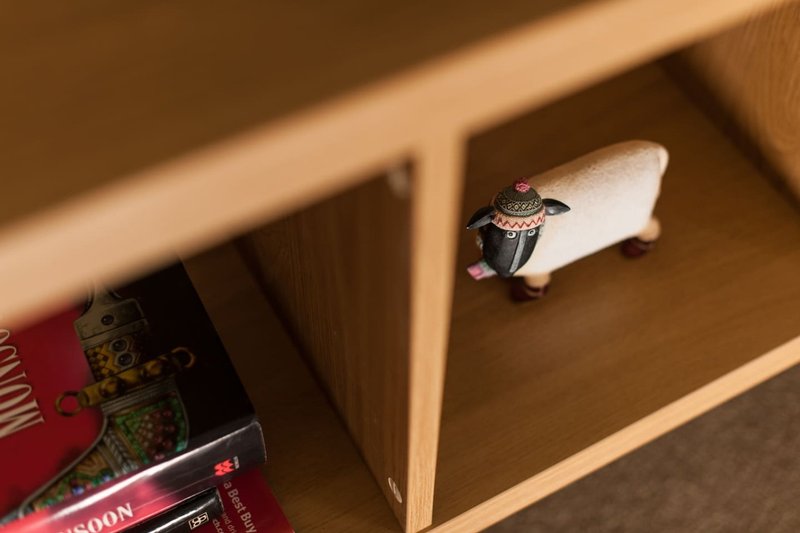 Wooden shelf with decorative items including a ring and small objects