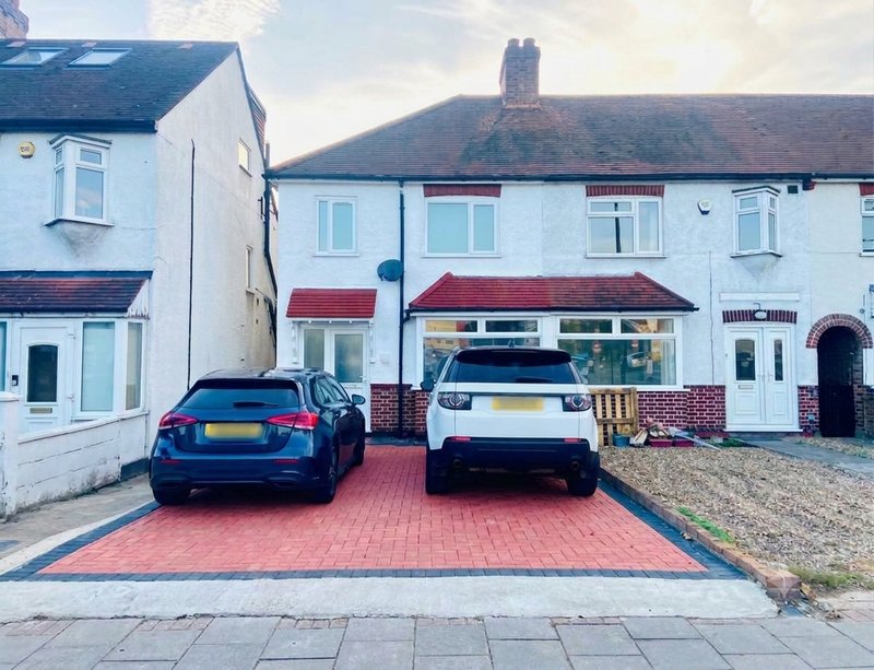Semi-detached house with driveway, two parked cars, and brick front elevation