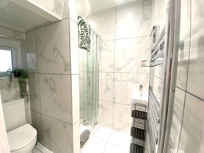 Modern bathroom with walk-in shower, marble tiles, heated towel rail and toilet