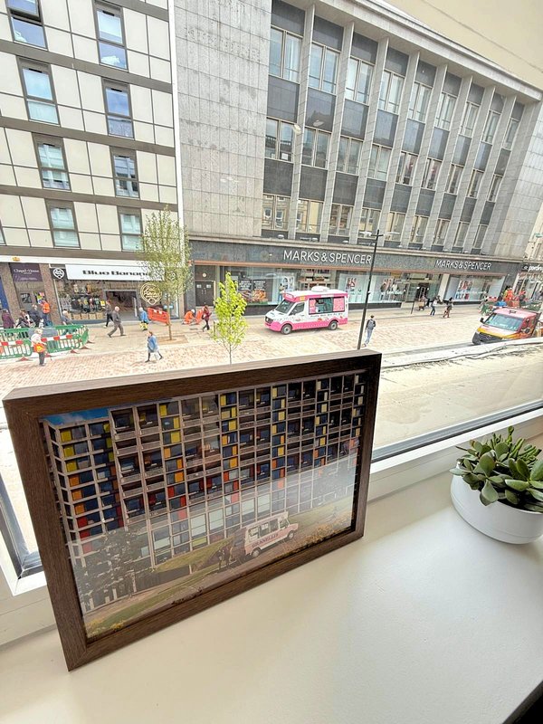 Window sill with decorative wooden display box and potted plant, urban street view beyond