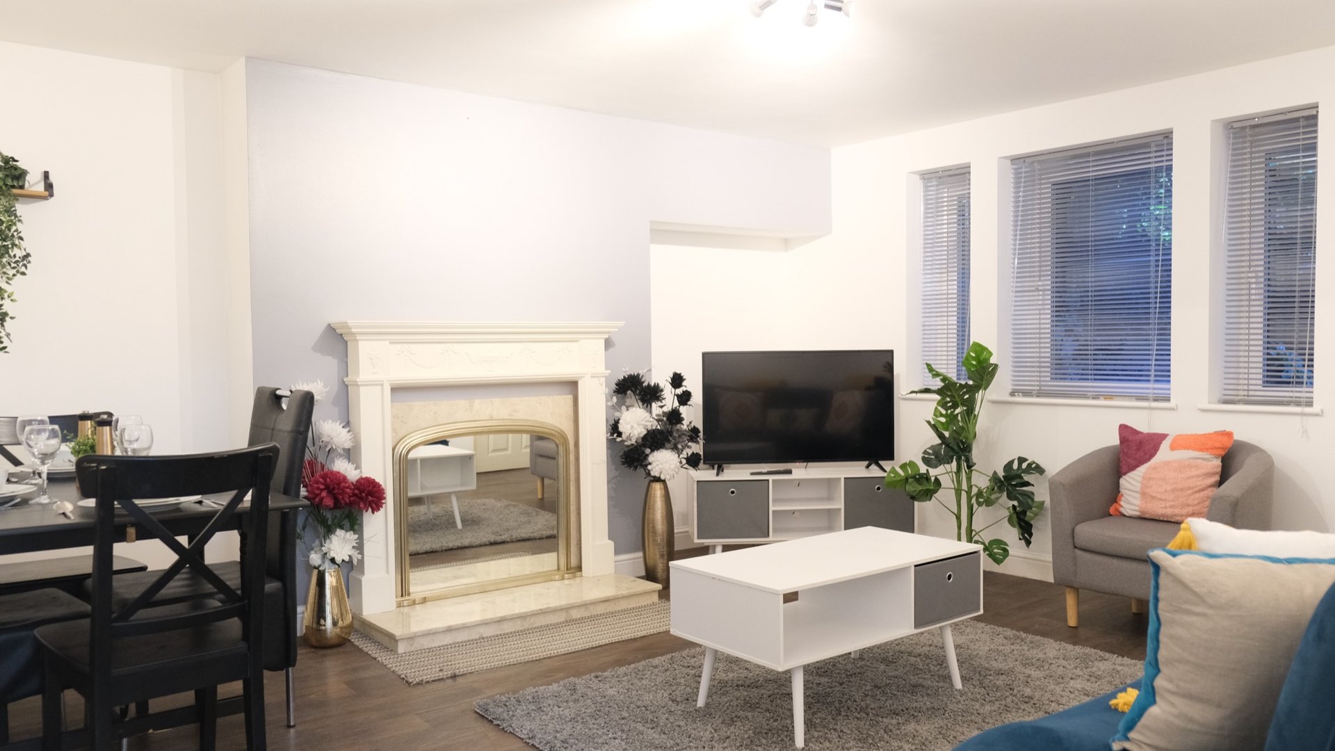 Bright living room with fireplace, TV, sofa, coffee table and dining area