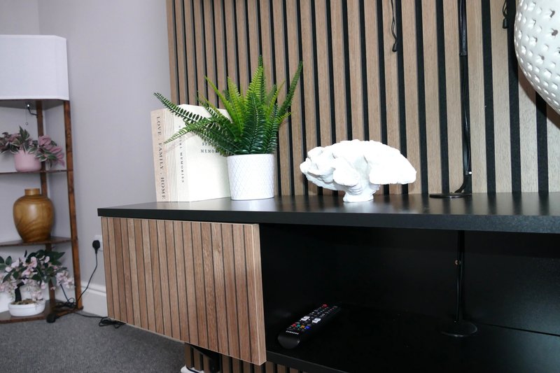Modern desk with potted plants, lamp, and wall-mounted shelving with decor