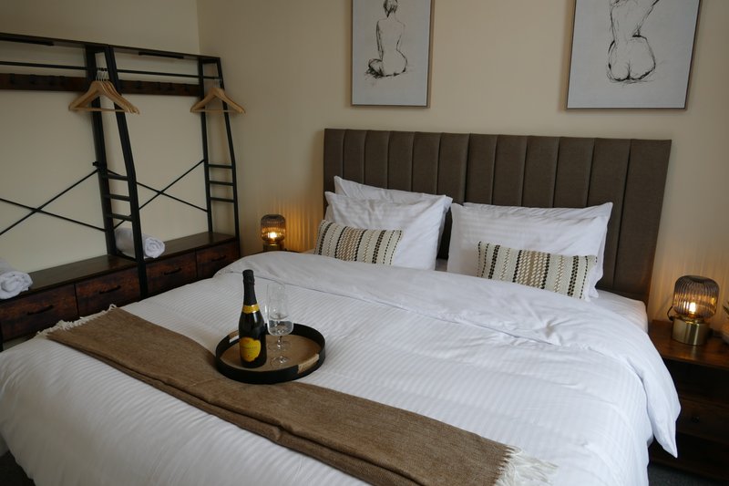 Bedroom can either have a with super king  bed or 2 x 3ft single beds. Grey upholstered headboard, wine bottle and glasses on bed runner. Bedside cabinets have USB connectors