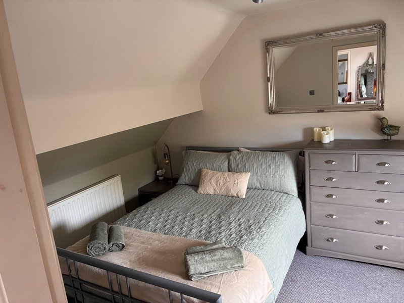 Bedroom 2 -  double bed, grey dresser, mirror, and two-tone wall paint