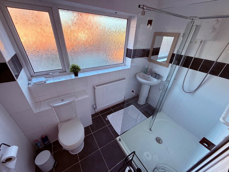 Modern bathroom with toilet, sink, shower enclosure and large window