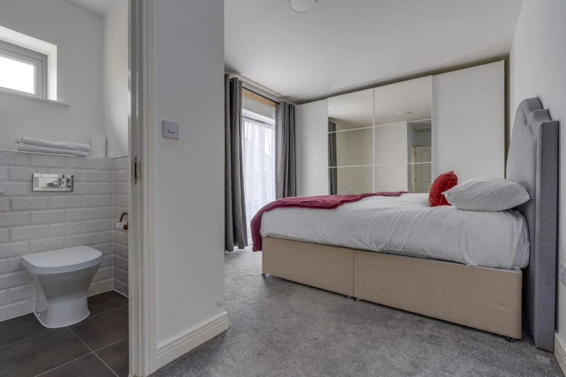 Bedroom with double bed, mirrored wardrobe, and ensuite bathroom with toilet