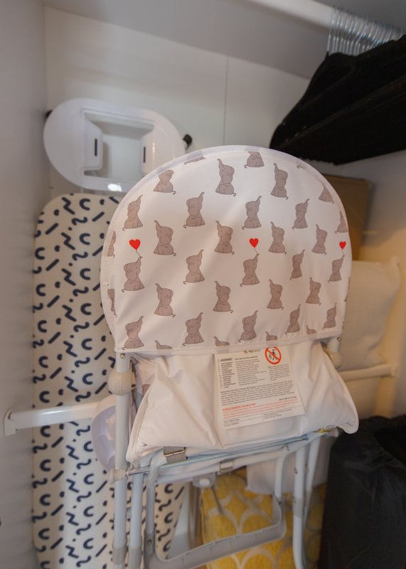Bathroom storage shelves with folded towels, patterned fabrics, and a decorative cushion