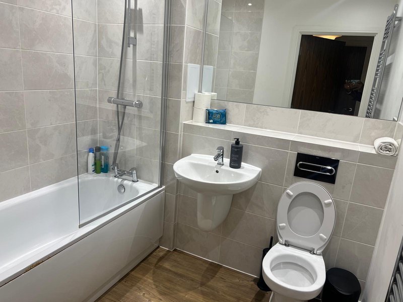 Modern bathroom with bathtub, shower enclosure, pedestal sink and toilet