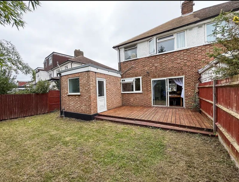 Brick house with rear garden, wooden deck, and single-story extension