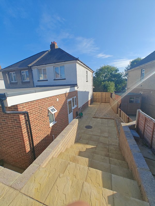 Semi-detached house with brick and rendered exterior, paved driveway and fenced garden area
