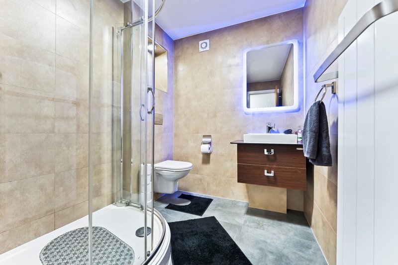 Modern bathroom with shower enclosure, vanity sink, mirror and heated towel rail