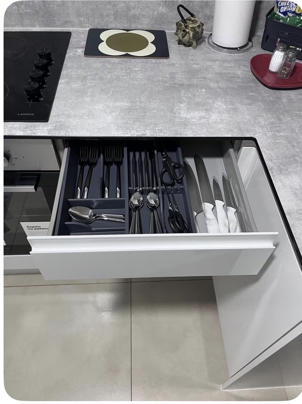 Kitchen drawer open showing organized utensils, cutlery and kitchen tools