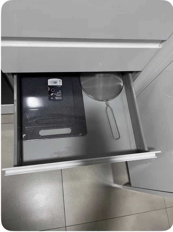 Open kitchen drawer showing microwave appliance and cooking utensils inside