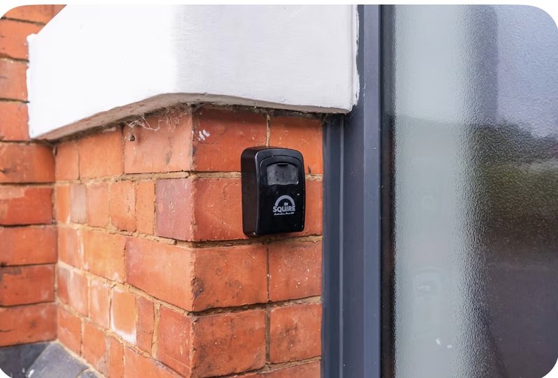 Exterior brick wall with doorbell button and dark door frame detail