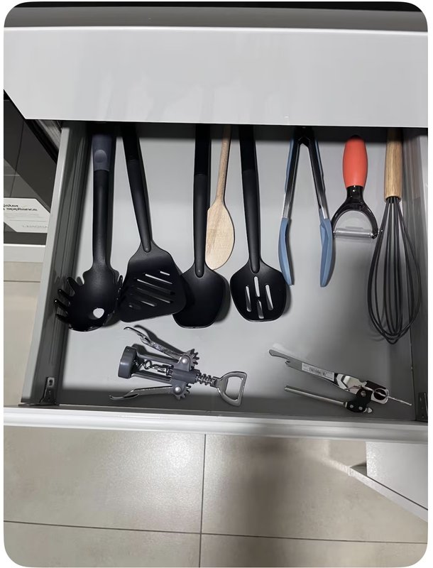 Kitchen drawer organizer with cooking utensils, spatulas, whisks, and small appliances neatly arranged