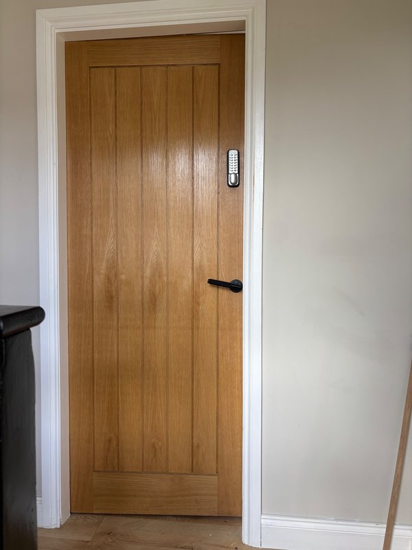 Wooden interior door with white frame and black hardware in hallway