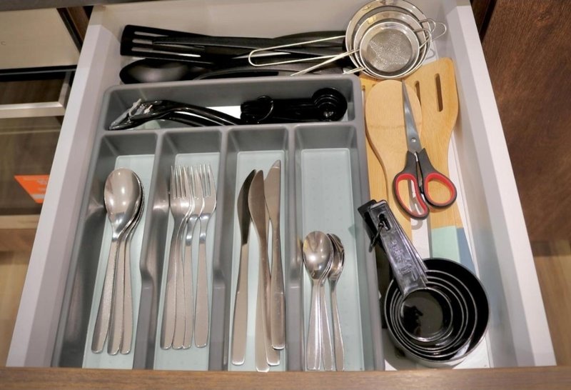Kitchen drawer organizer with cutlery, utensils, scissors and measuring cups