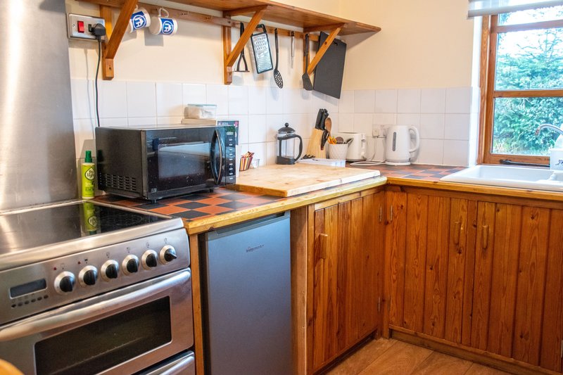 Wooden kitchen with stainless steel stove, microwave, kettle and countertop appliances