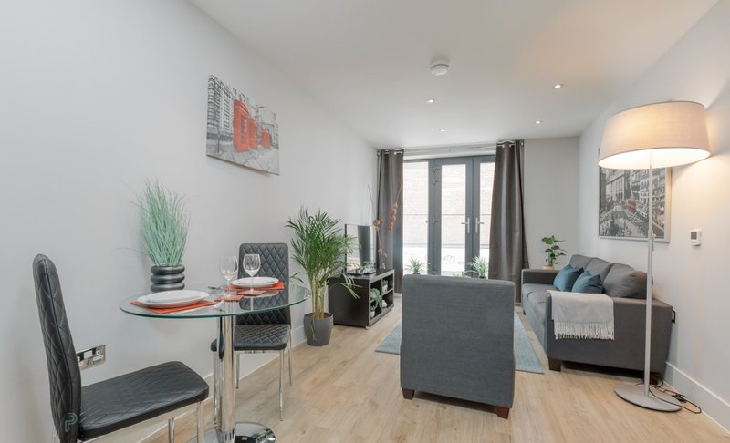 Modern open-plan living room with sofa, dining table.
